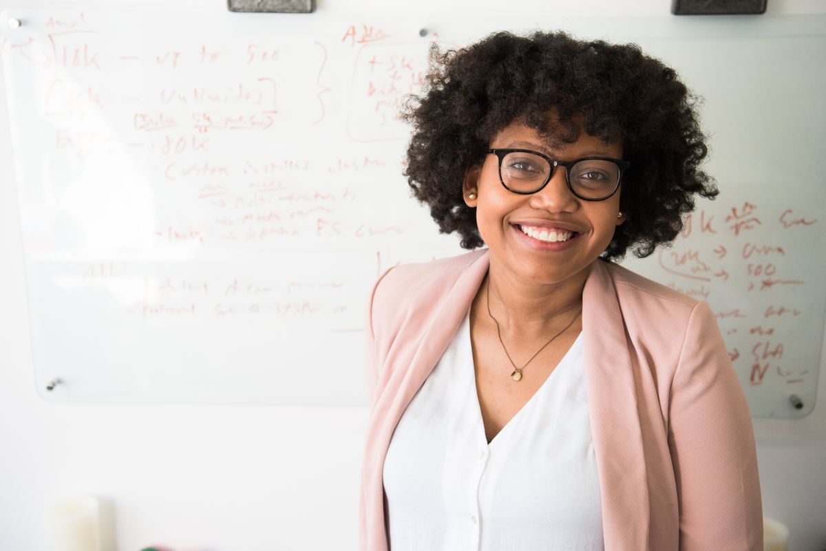 Confident professional smiling in front of a whiteboard